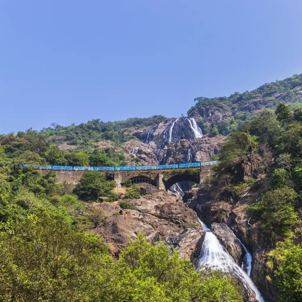 Dudhsagar Waterfalls Goa train crossing bridge over cascading falls amid lush green hills