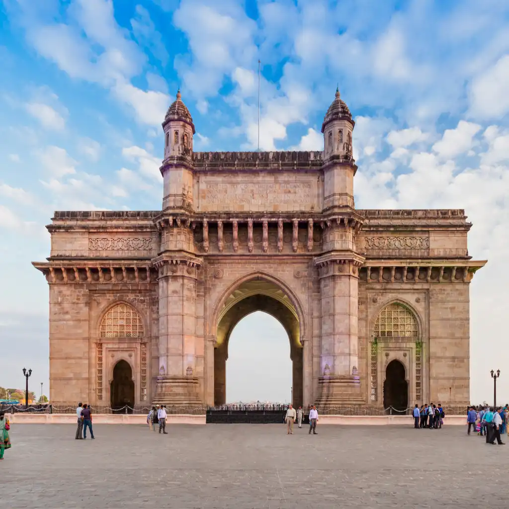 Gateway of India, Mumbai monument with visitors in the plaza under blue sky