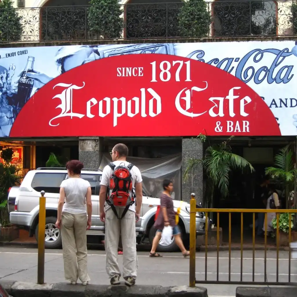 Leopold Cafe Mumbai exterior on Colaba Causeway with iconic red sign and visitors outside