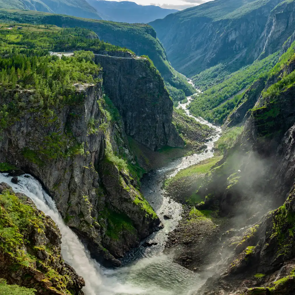 Voringsfossen waterfall plunging into Norway's steep canyon with winding river and mountain views