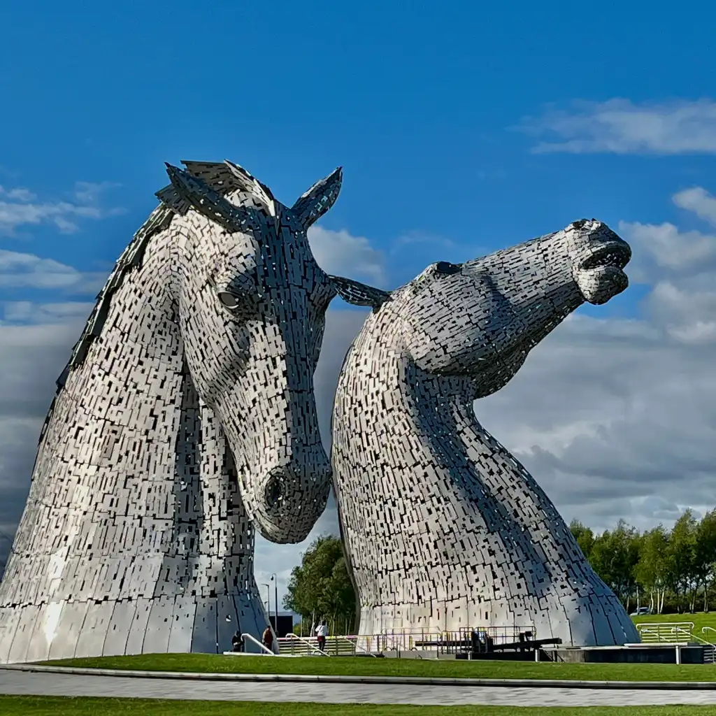 Kelpies Scotland two giant steel horse head sculptures under blue sky