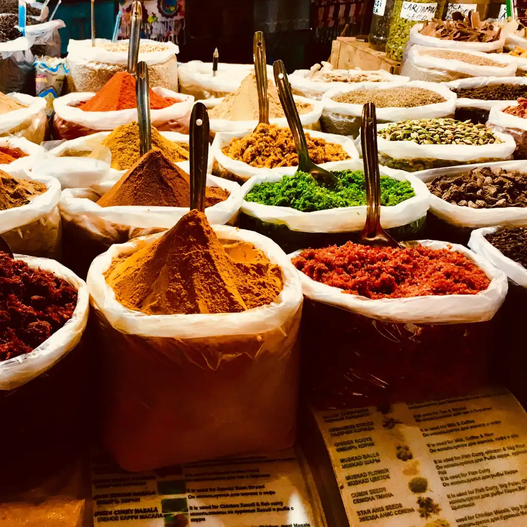Vibrant spices at Mapusa Friday Market Goa with colorful powders in sacks and metal scoops
