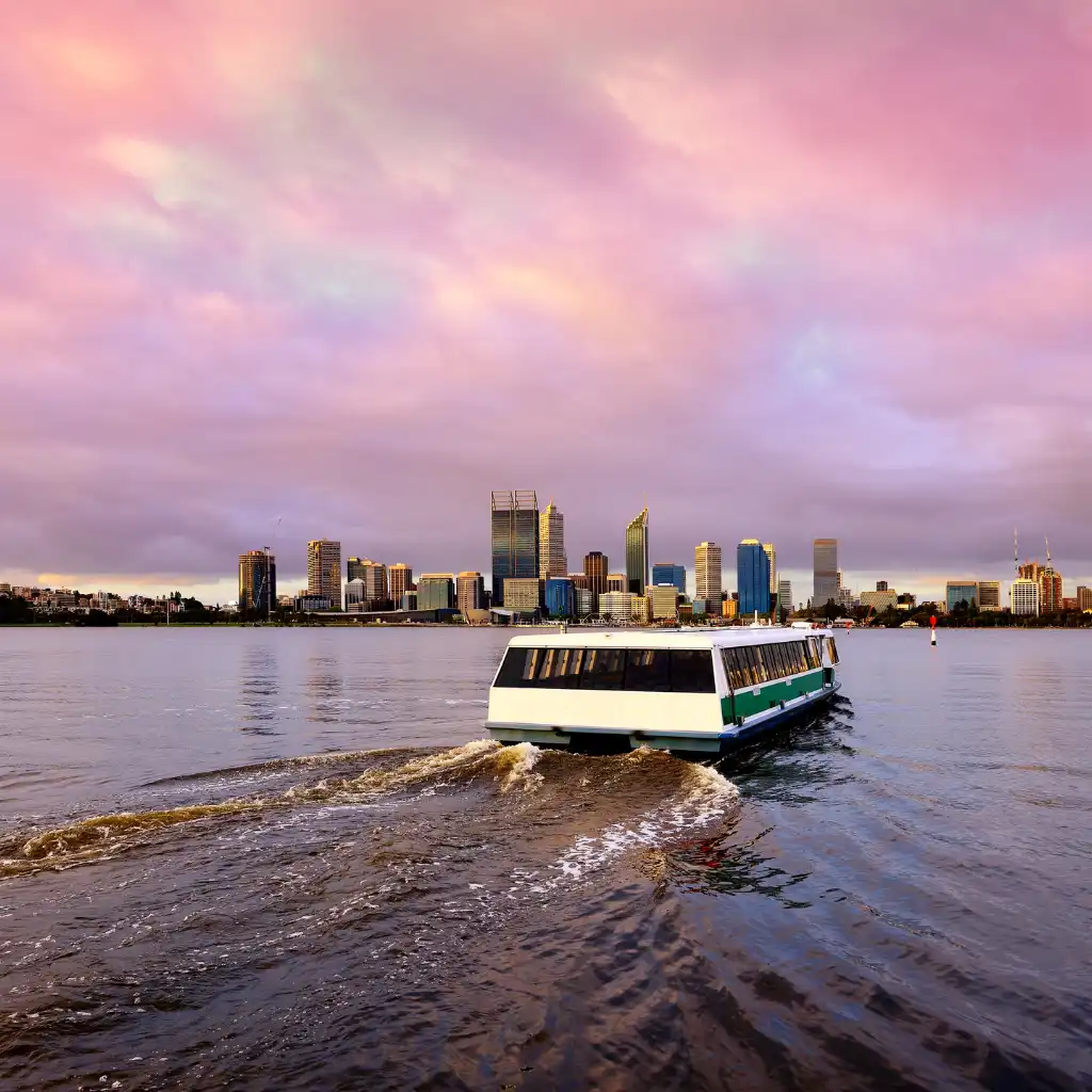Perth Ferry cruising past city skyline at sunset on the water