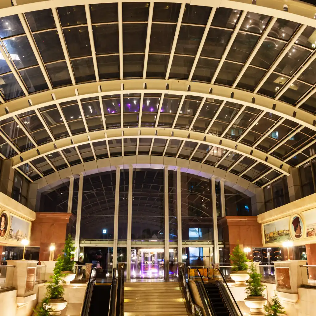 UB City Bengaluru luxury mall interior with arched glass ceiling, escalators and night view