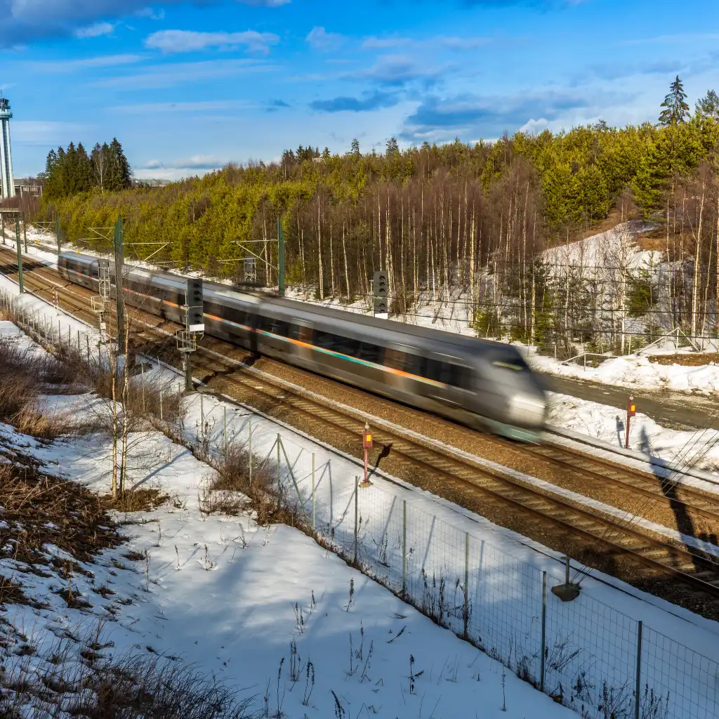Airport Train, Oslo speeding through snowy Norwegian forest on scenic tracks