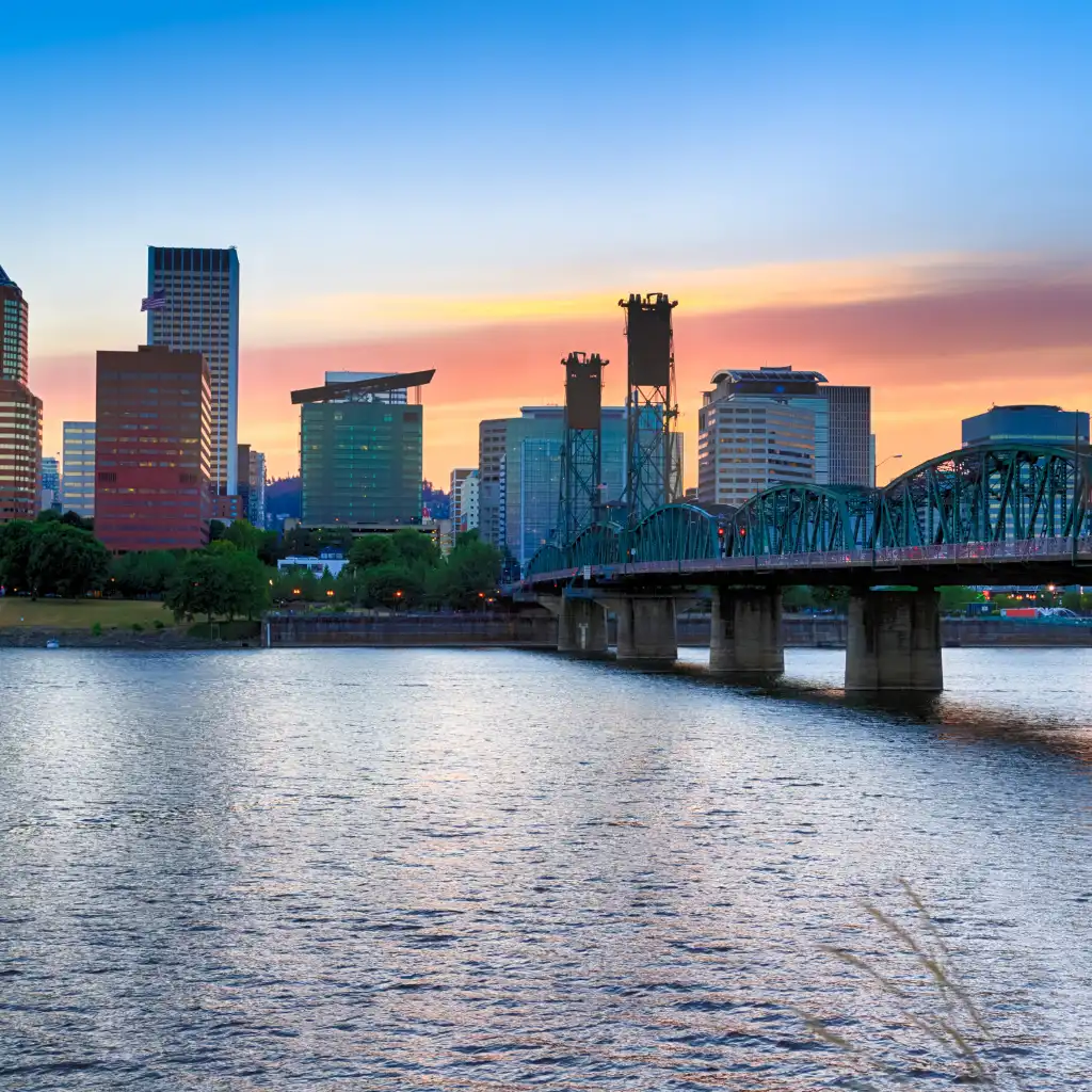 Portland Oregon skyline at sunset with green bridge over the river