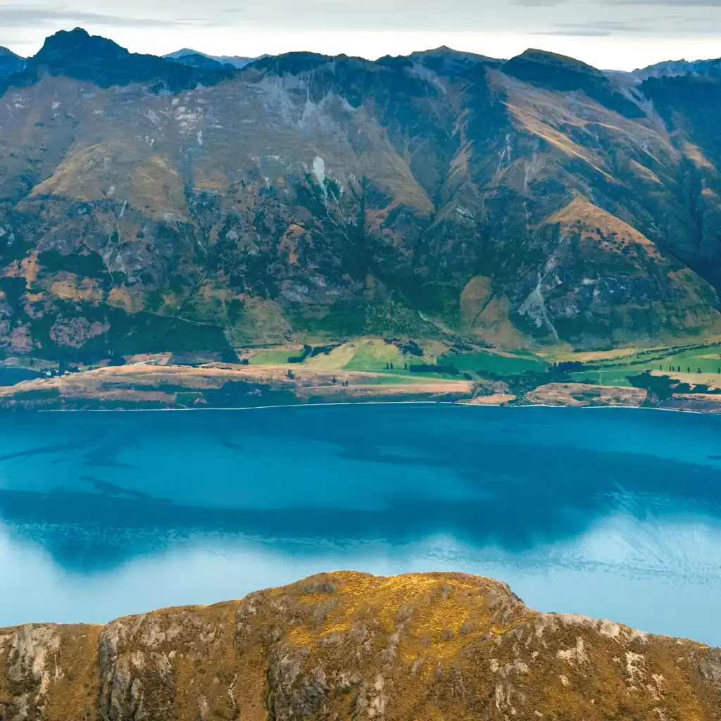 Aerial view on scenic flight from Milford Sound to Queenstown over turquoise lake and rugged mountains