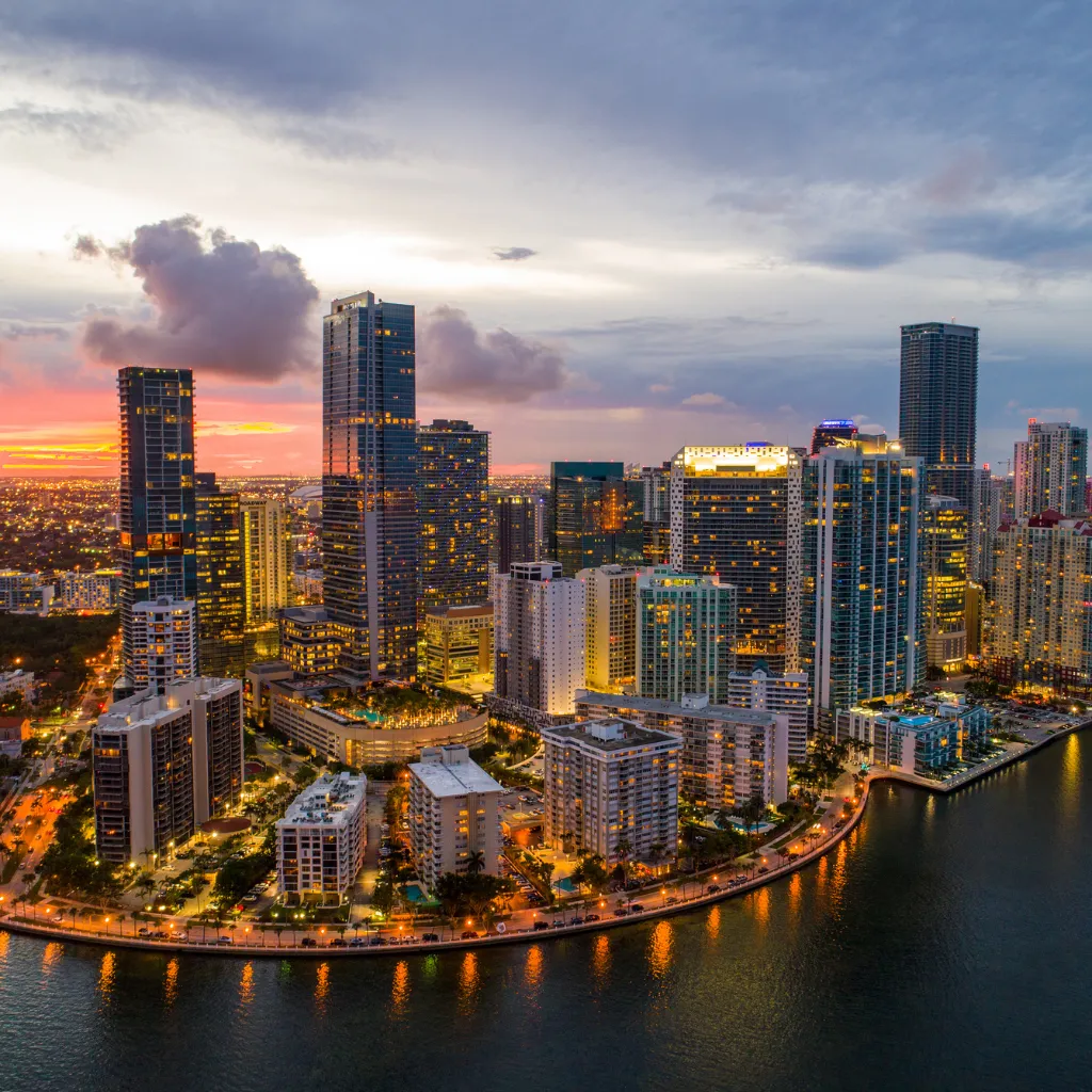 Brickell Miami skyline at dusk with glowing high-rises reflecting on the waterfront