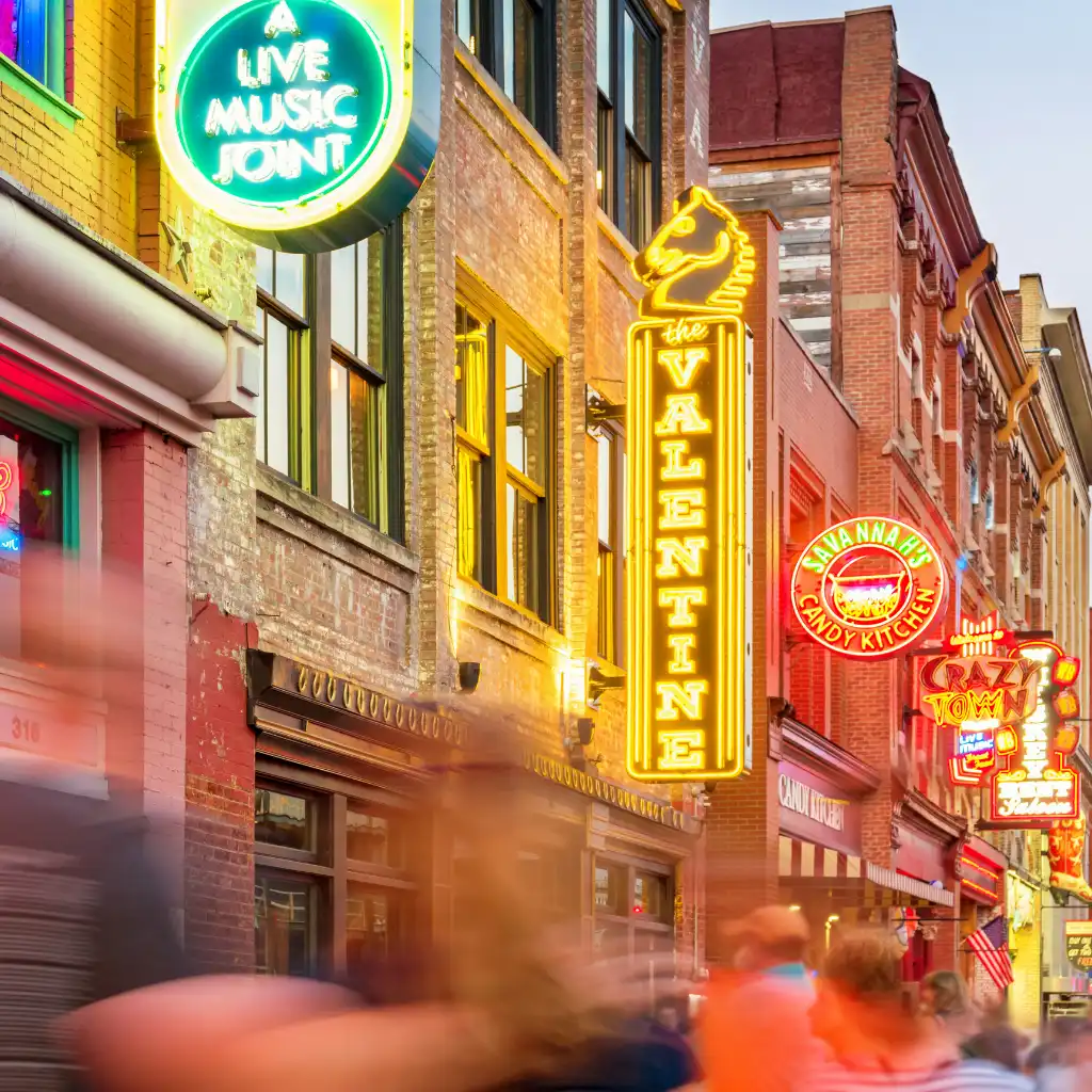 Lower Broadway Nashville vibrant neon signs and crowds at live music venues and shops at dusk