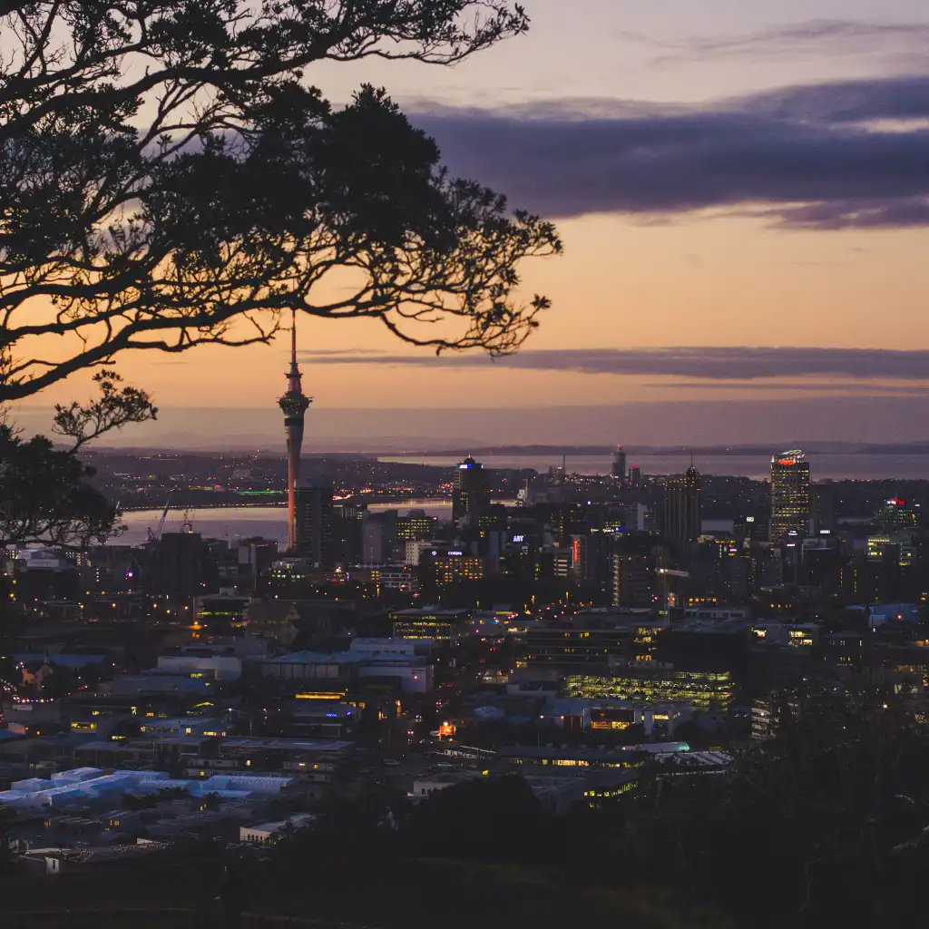 Mount Eden Auckland sunset view of Sky Tower over city skyline and harbor
