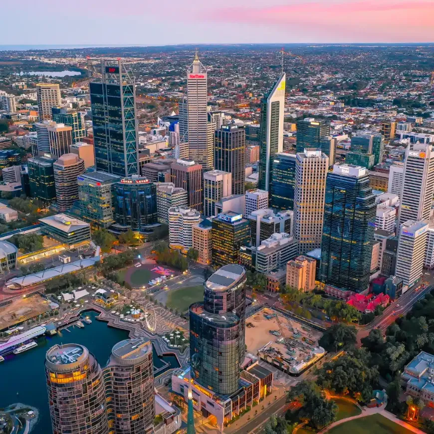 Perth skyline at dusk with skyscrapers, riverfront and Ferris wheel attractions