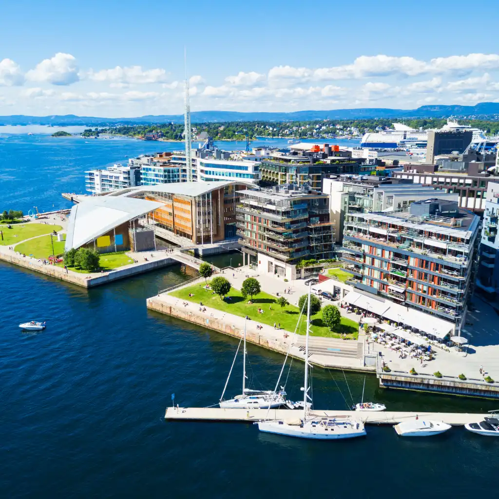 Aker Brygge waterfront with modern buildings, marina sailboats and Oslo fjord views in Norway