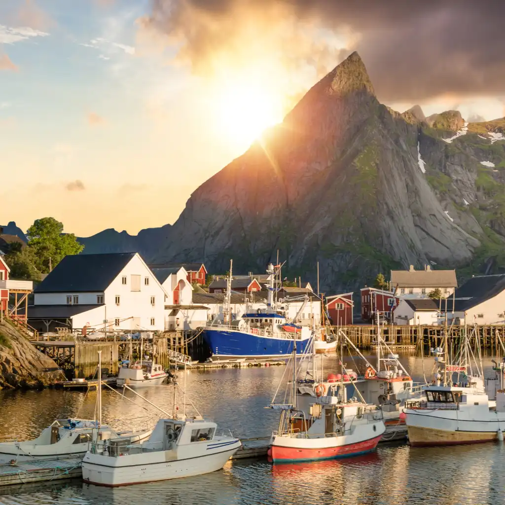 Lofoten Islands Norway sunset over fishing boats in mountain harbor village