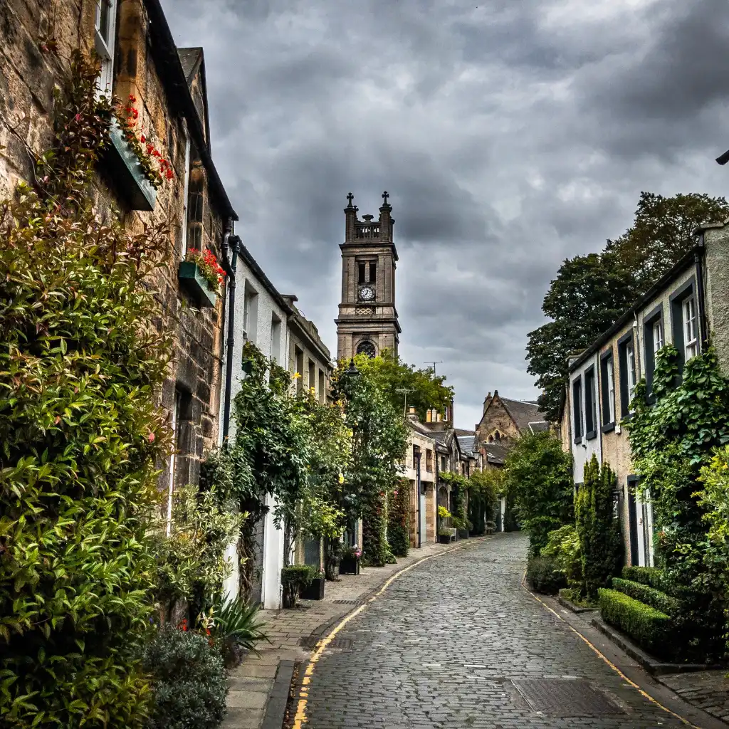 Circus Lane Edinburgh Scotland cobblestone street with clock tower and ivy-covered buildings