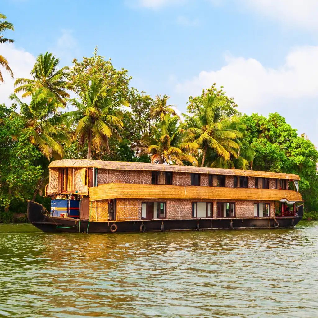 Houseboat on Alleppey Backwaters Kerala with palm trees lining the shores