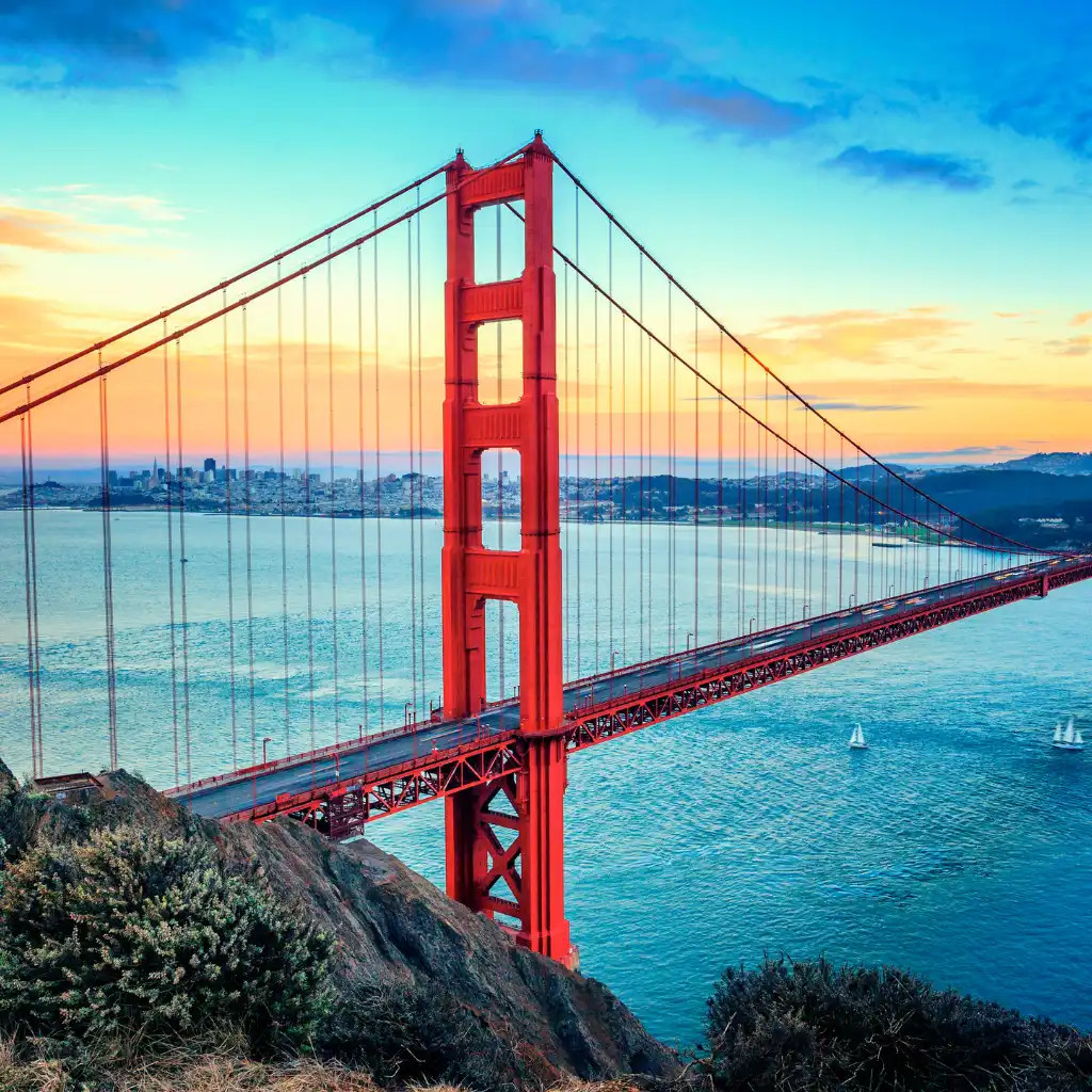 Golden Gate Bridge California at sunset from rocky standing viewpoint over the bay