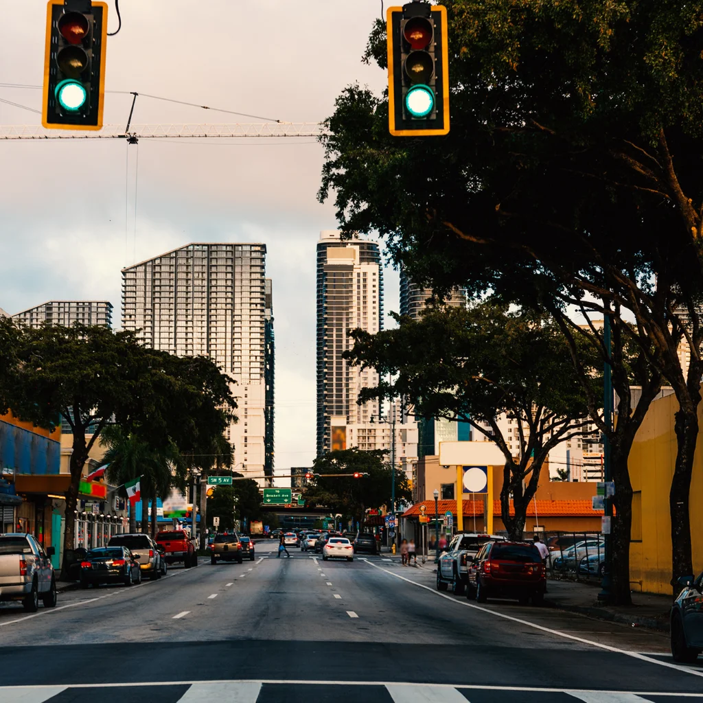 Little Havana Florida street with traffic lights cars and high rises at dusk