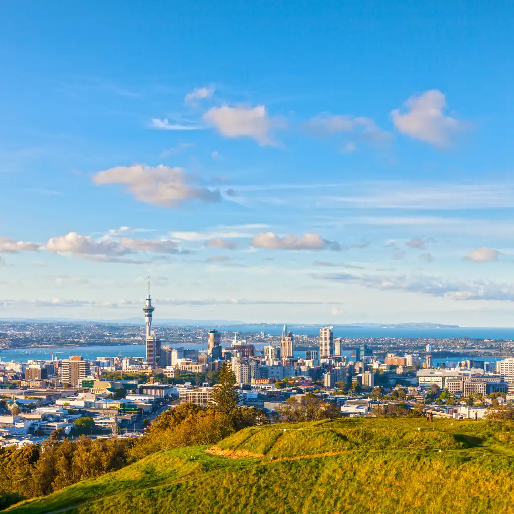 Mount Eden Auckland skyline view with Sky Tower, city buildings and harbor beyond