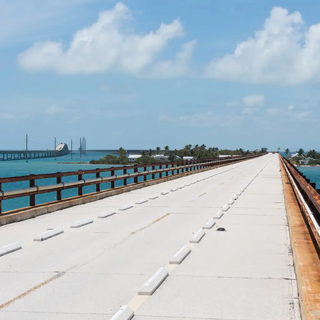 Seven Mile Bridge Florida empty lane over turquoise waters with palms under blue sky