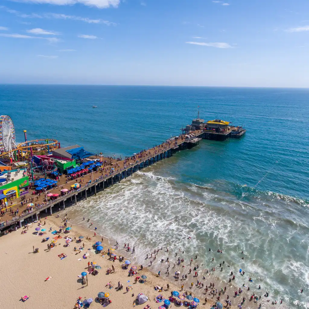 Santa Monica Pier Los Angeles aerial view of crowded beach with Ferris wheel and ocean waves