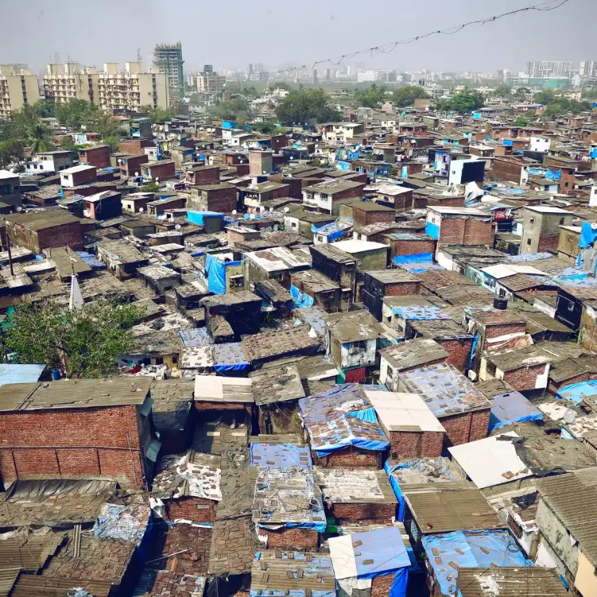Dharavi Mumbai aerial view of dense slum with colorful rooftops and city skyline beyond