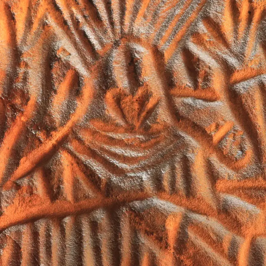 Ancient petroglyphs at Edakkal Caves in Wayanad showing carved figures with radiating patterns on rock
