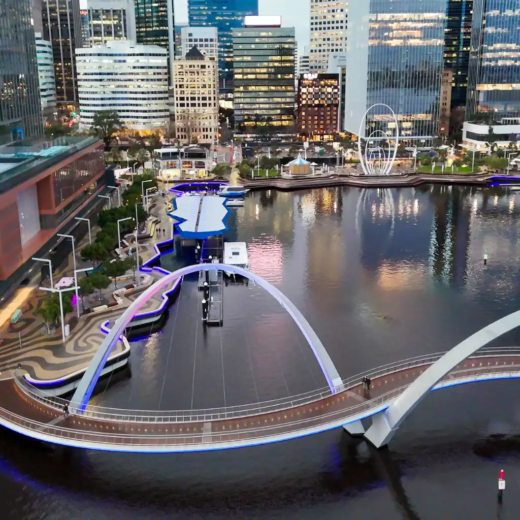 Elizabeth Quay Perth arched bridge glowing at dusk with river reflections and city skyline