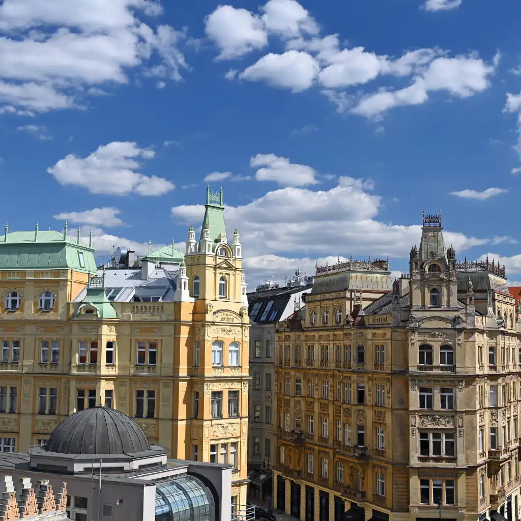 Historic buildings with ornate towers in Jewish Quarter Prague under blue skies