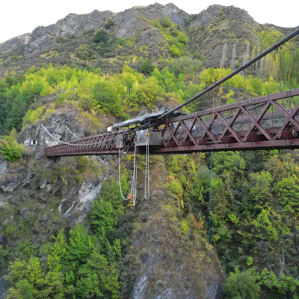 Kawarau Bungy bridge in Queenstown with hanging cords over lush mountain gorge
