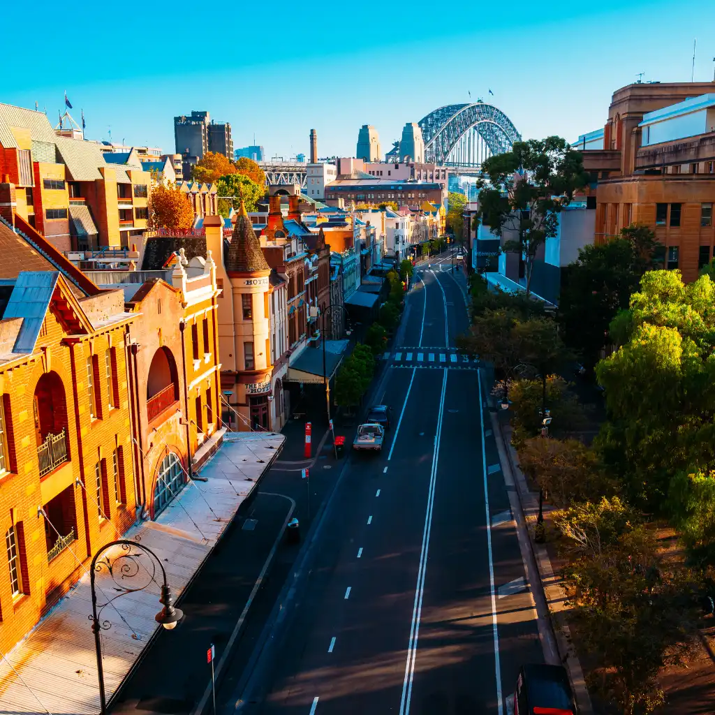 The Rocks Sydney historic street with sandstone buildings and Harbour Bridge view