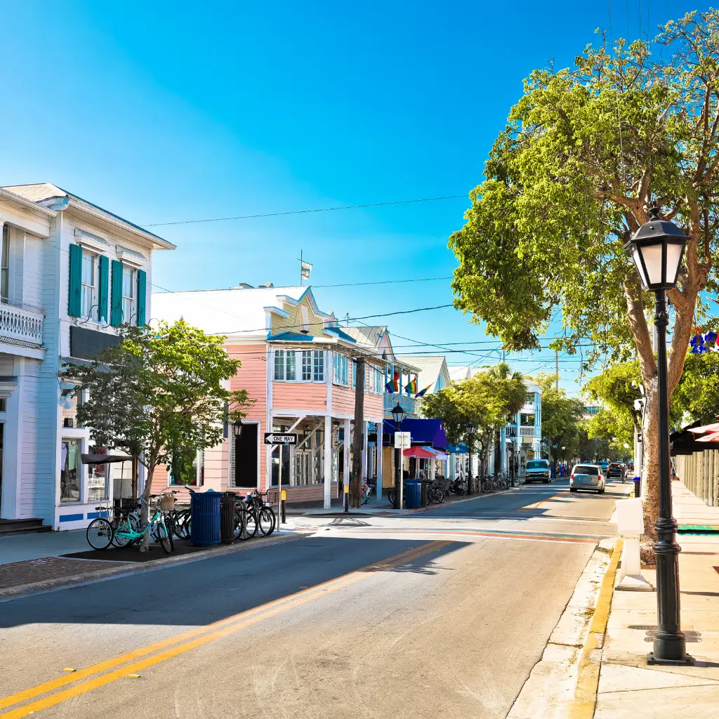 Duval Street Miami sunny view of colorful buildings bicycles and palm trees in Florida