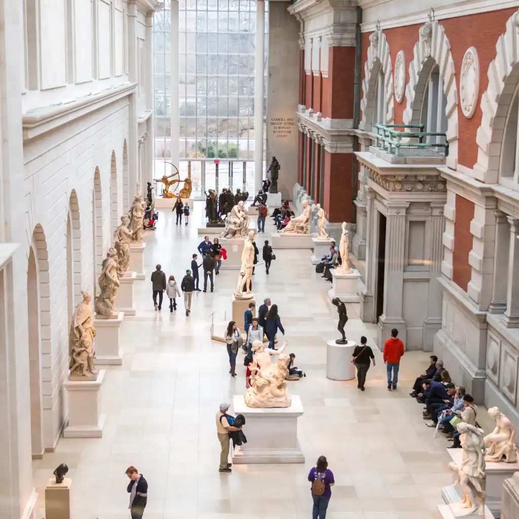 Visitors exploring sculptures in the grand hall at Metropolitan Museum of Art, New York