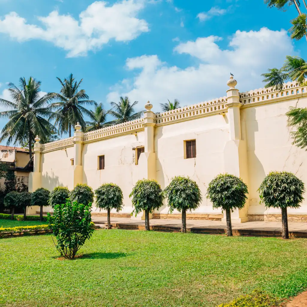 Tipu Sultan's Summer Palace Bengaluru historic facade and manicured garden with palm trees