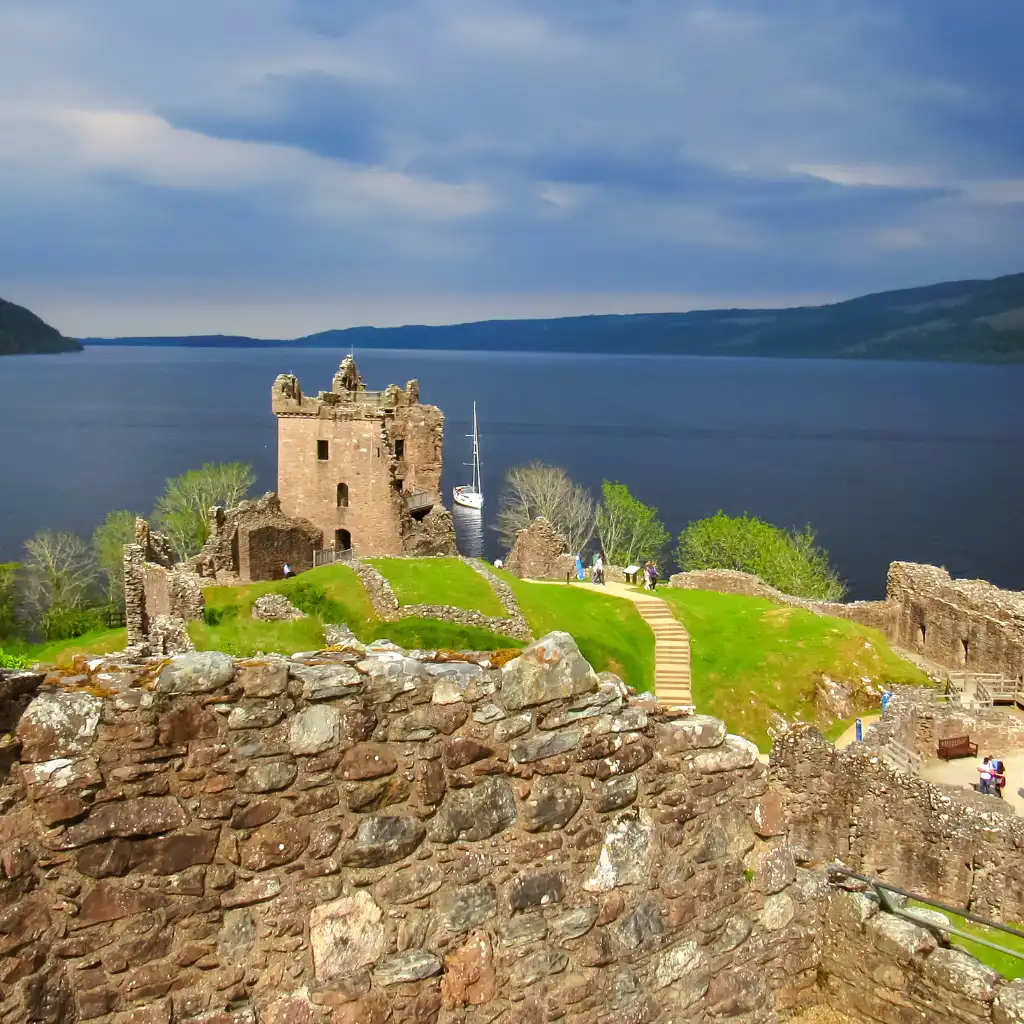 Urquhart Castle ruins overlooking Loch Ness Scotland with stone walls and visitors
