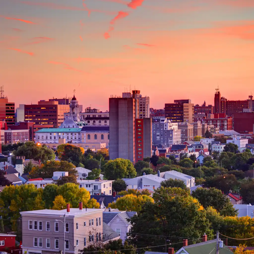 Downtown Portland skyline at sunset with high-rises, homes and colorful autumn trees near parks