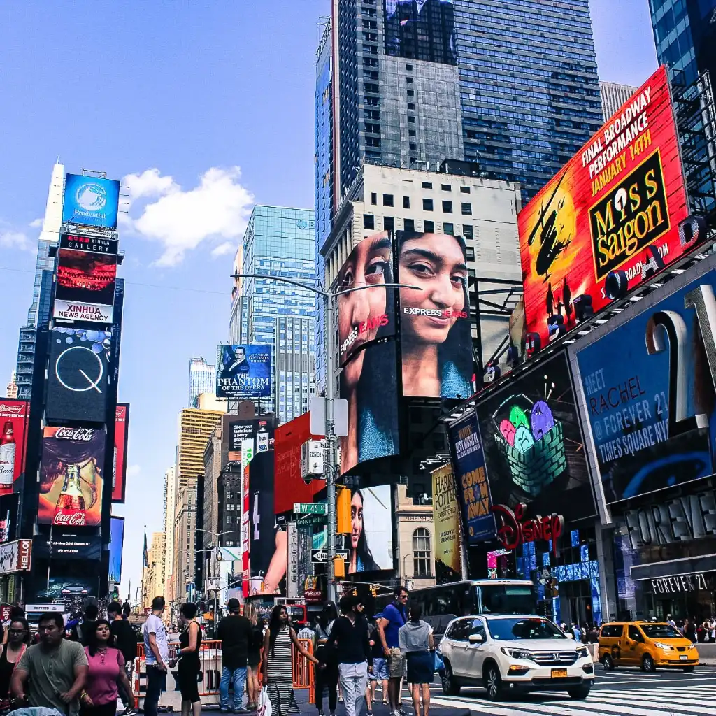 Times Square, New York bustling with crowds, yellow taxis and giant digital billboards
