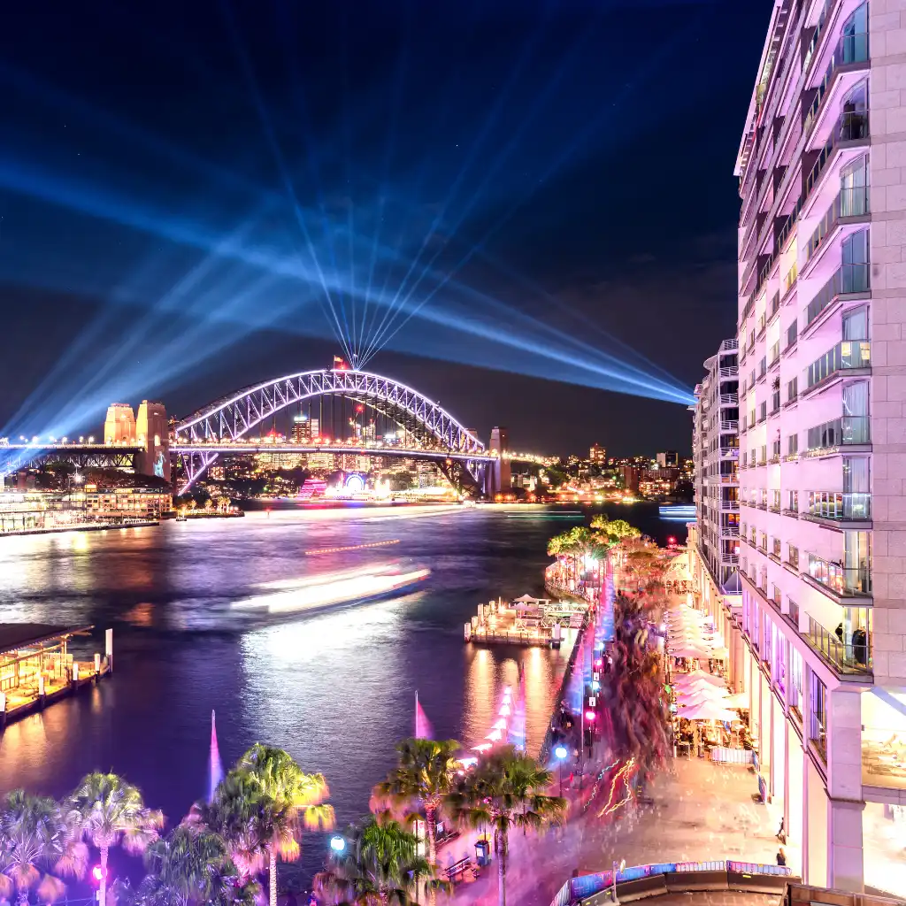Circular Quay Sydney waterfront at night with illuminated Harbour Bridge and city lights
