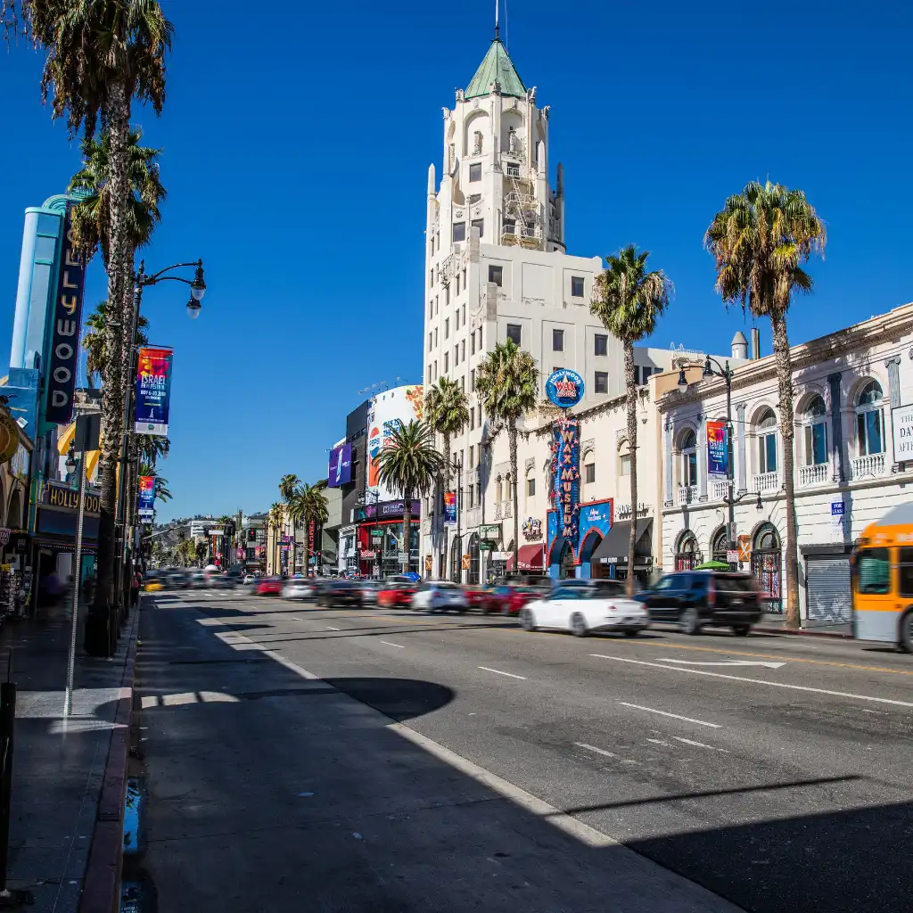 Hollywood Boulevard, Los Angeles with palm trees, traffic and historic buildings under blue sky