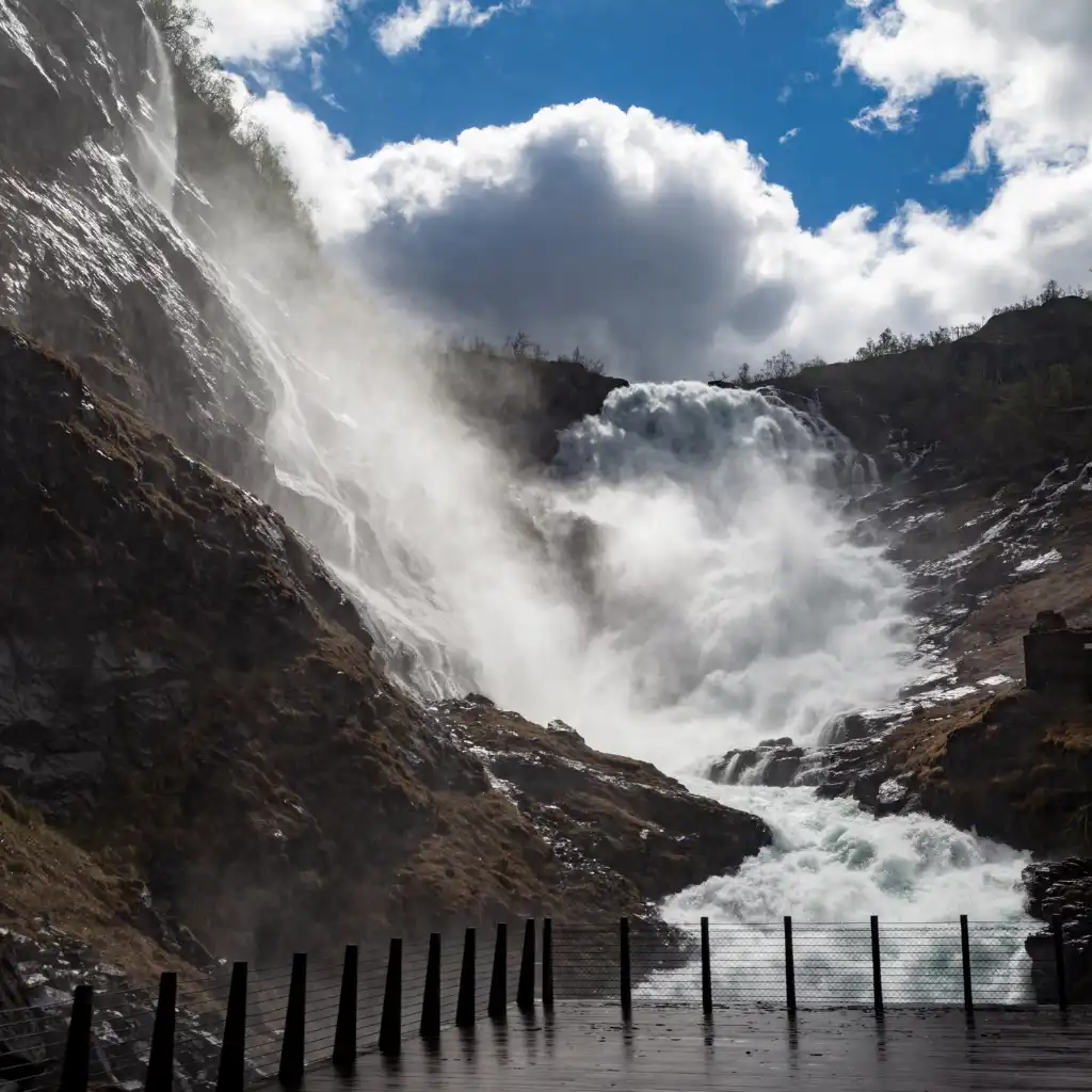 Kjosfossen Waterfall Norway cascading with mist over rocky cliffs from wet viewing platform