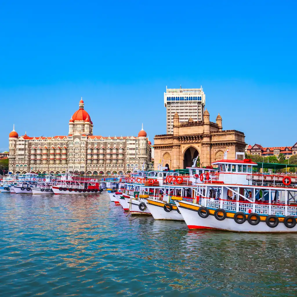 Mumbai, India boats docked at Gateway of India with Taj Mahal Palace hotel behind
