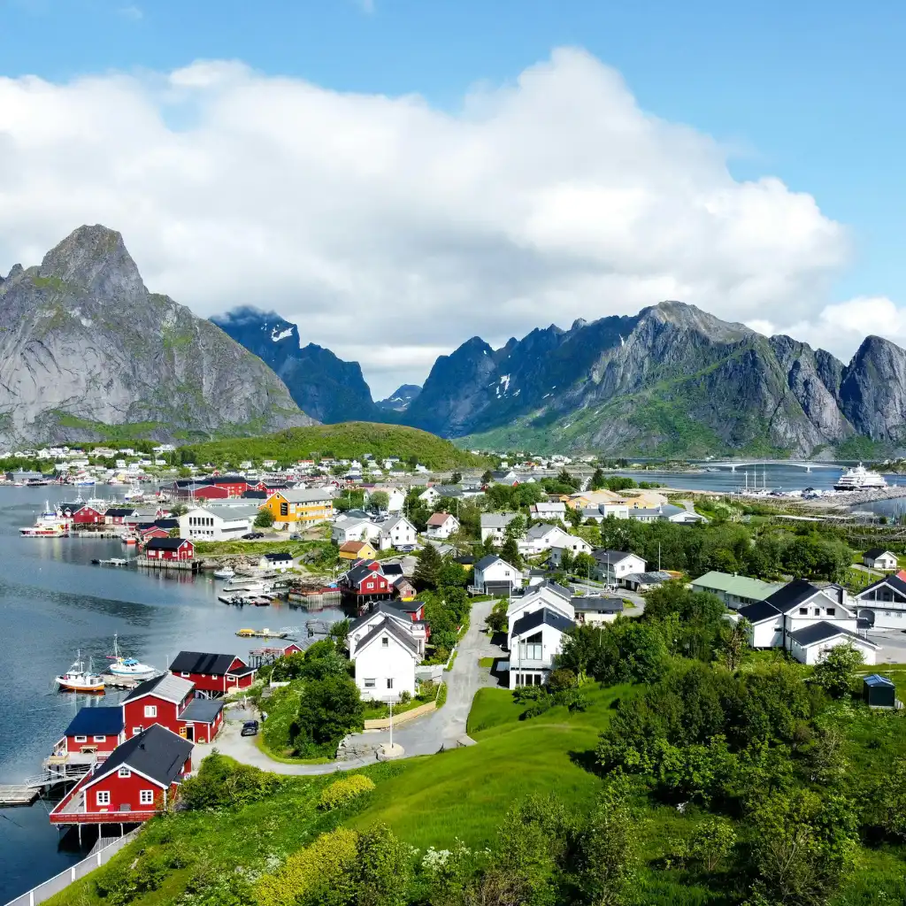 Reine Village, Norway: red houses by fjord with dramatic mountains and harbor view