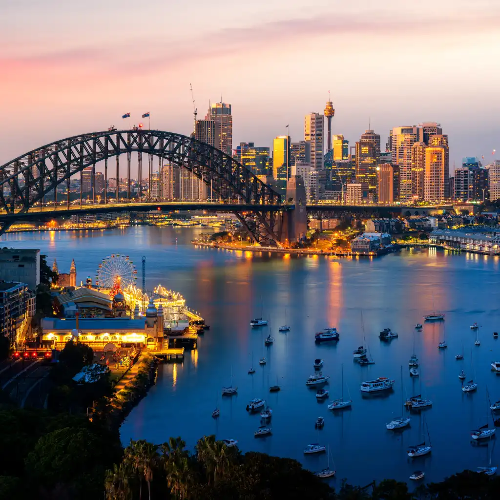 Sydney Harbour Bridge at twilight with Sydney skyline, boats on the harbour and city lights